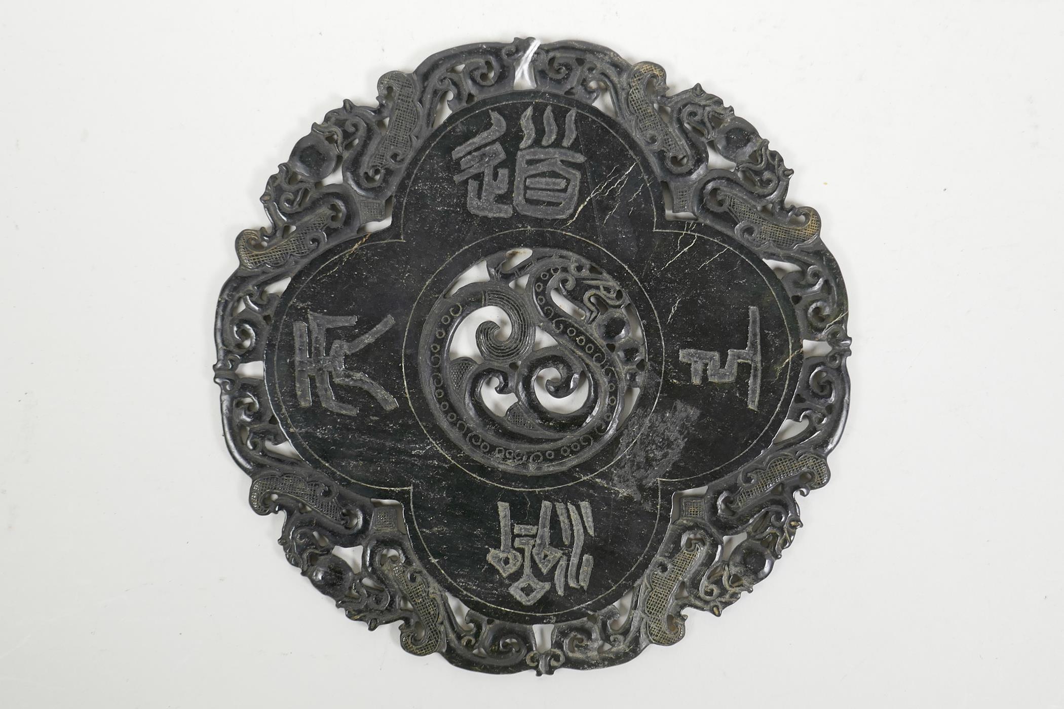 A Chinese black hardstone tablet with carved and pierced dragon and auspicious character decoration,