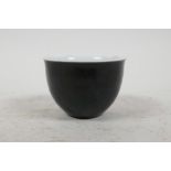 A small Chinese famille noire wine cup painted with all over black glaze and 4 character mark to