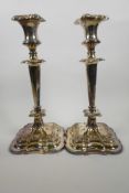 A pair of classical style Sheffield plated candlesticks, with cast floral decoration on shaped