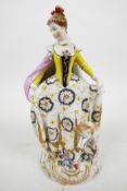 A C19th Chelsea style porcelain figure of an elegant C18th lady with a lamb and floral sprays to the
