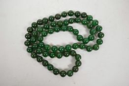 A string of dark green jade beads, 32" long