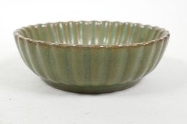 A Chinese Song style olive glazed pottery dish of ribbed form, with raised tree decoration to the