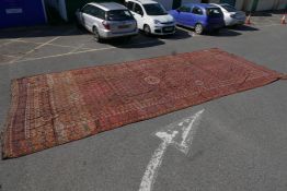 A large C19th Turkmeni red ground carpet with all over geometric design, A/F well worn, 302" x 126"