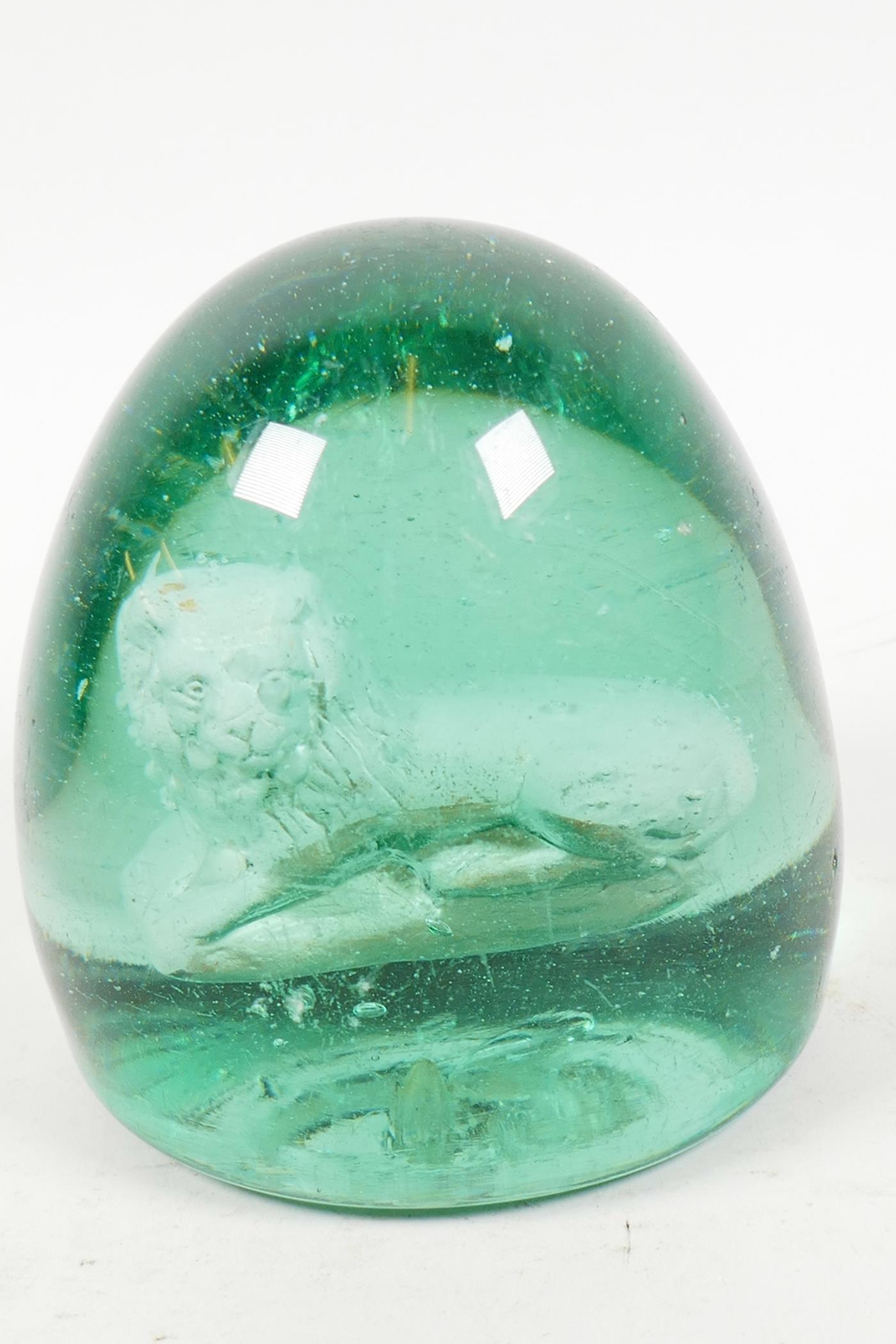 A heavy C19th green glass dump with interior sulphide of a lion, 3½" diameter, 4" high