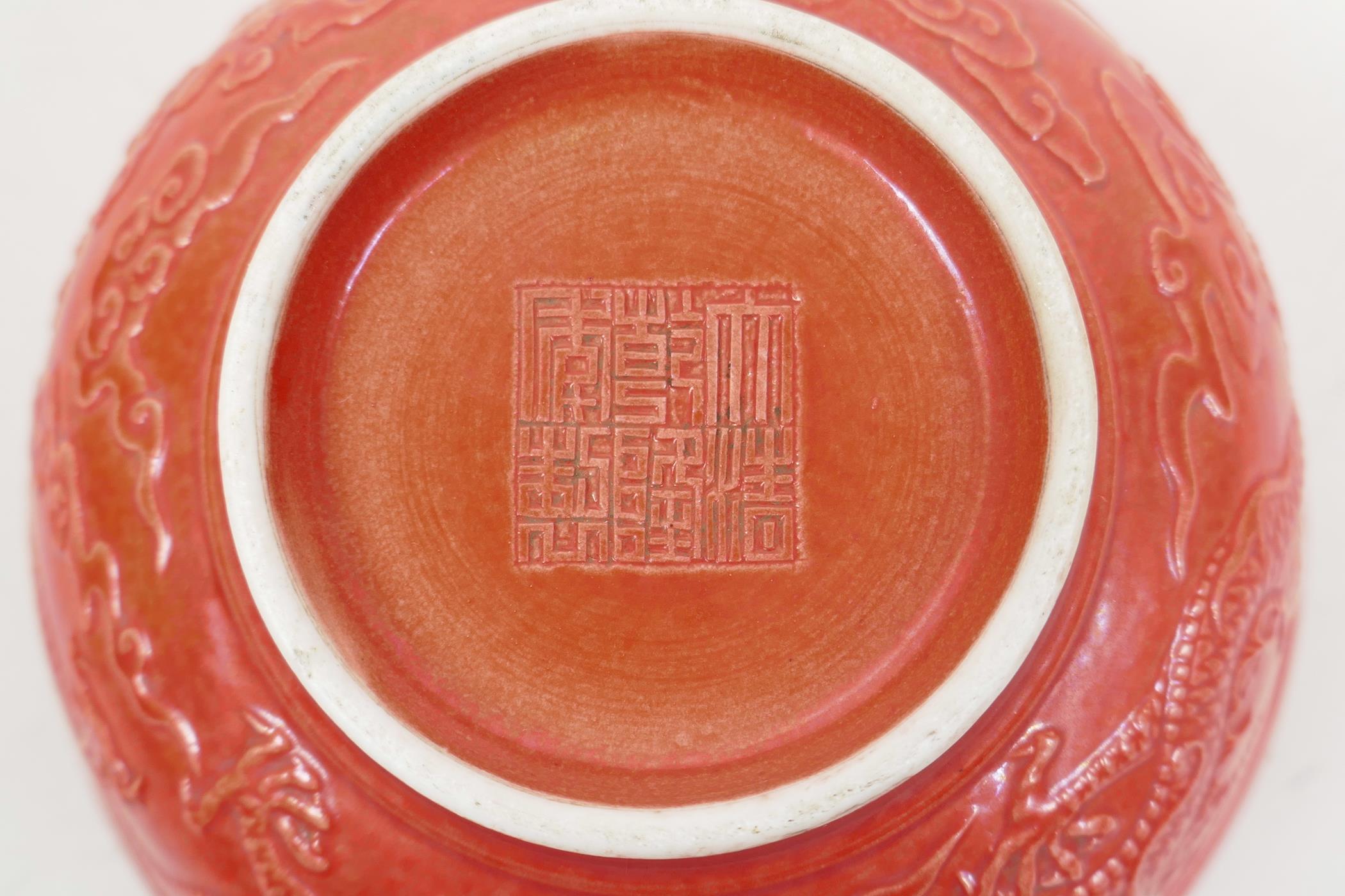 A Chinese red ground porcelain rice bowl with raised dragon decoration, impressed seal mark to base, - Image 4 of 4