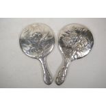 A hallmarked silver hand mirror with repousse cherub decoration (Birmingham 19030, and another