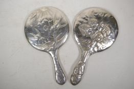 A hallmarked silver hand mirror with repousse cherub decoration (Birmingham 19030, and another