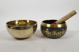 A Tibetan brass singing bowl, and another with script decoration, largest 5½" diameter