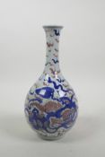A Chinese blue and white porcelain bottle vase decorated with fo dogs and highlighted with red,