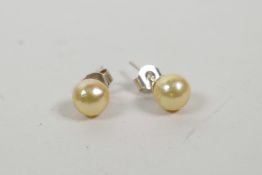 A pair of freshwater pearl stud earrings with silver posts