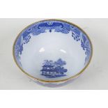 An early C19th English porcelain tea bowl, transfer printed with a variant on the Willow Pattern (