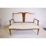 A Victorian inlaid mahogany open arm settee, with pierced and shaped back, raised on square tapering
