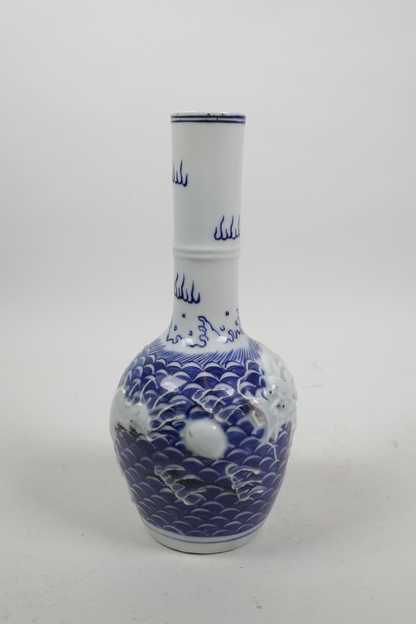 A Chinese blue and white porcelain bottle vase with raised decoration of a dragon chasing the - Image 4 of 5