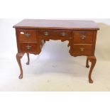 A C19th walnut five drawer kneehole desk, the top with cup corners, raised on cabriole supports with