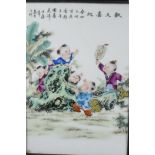 A Chinese carved hardwood table screen with porcelain panel decorated with boys at play, 27" high,