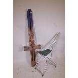 An artist's folding easel, 62" high, and a portable aluminium easel with seat