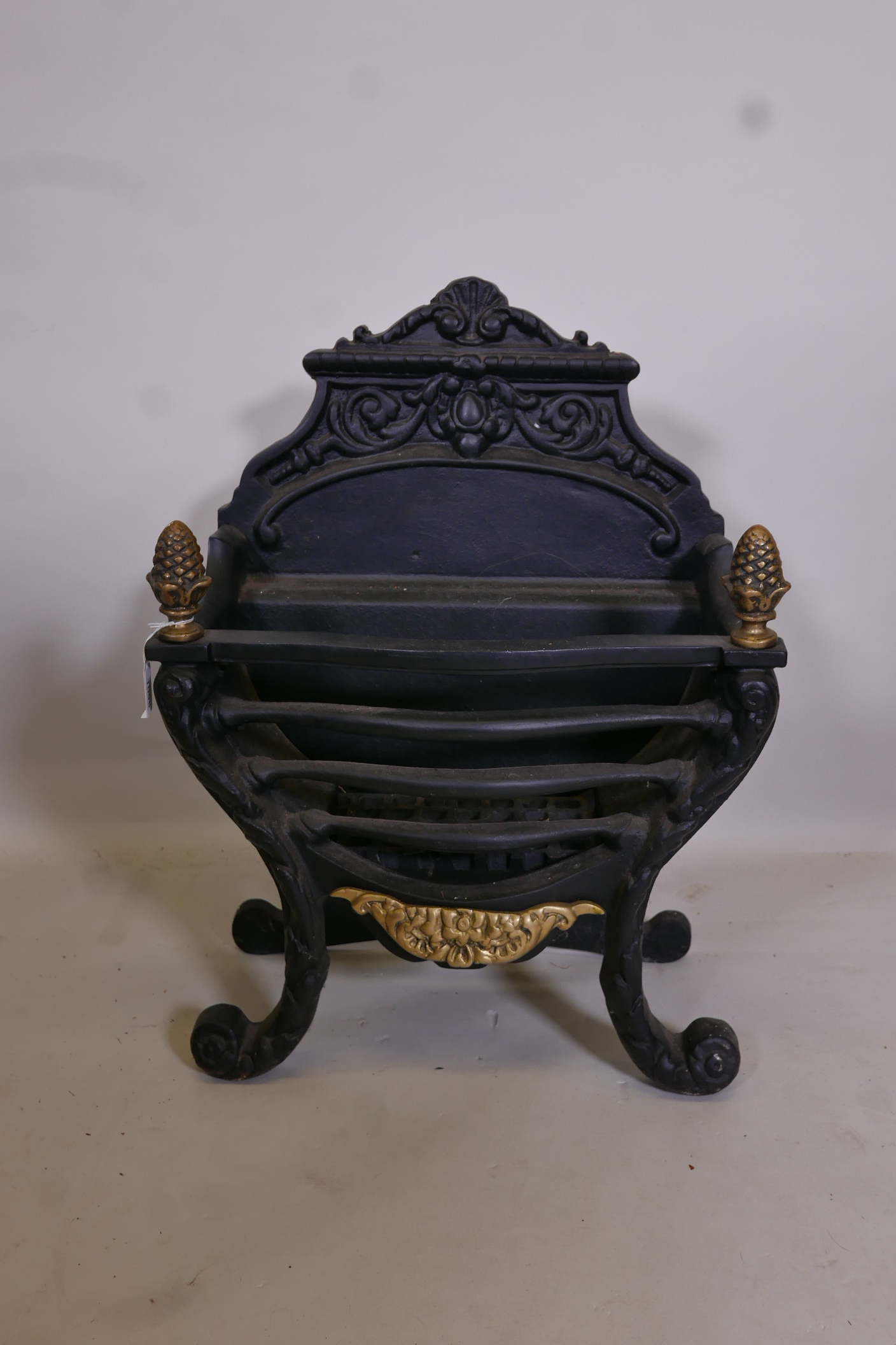 A heavy cast iron fire basket with brass decoration, 17" wide, 24" high x 9½" deep