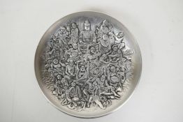 A Chinese white metal dish with raised decoration of Buddha and other deities, impressed seal mark