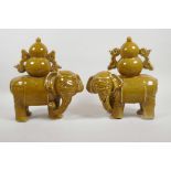 A pair of Chinese ochre glazed porcelain elephants carrying double gourds, 10" high