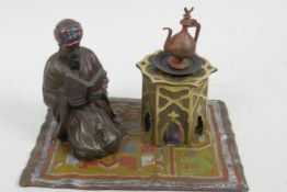 A cold painted bronze figure of an Arab gentleman kneeling on a rug, 5½" long, 3½" high