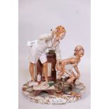 A Capodimonte figure group by Enzo Arzenton depicting a nurse and old man, 10" high