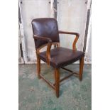 A 1930s oak office chair with leatherette upholstered back and seat