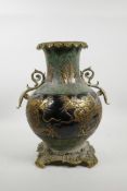 A Chinese mottled green and black pottery vase with ormolu style handles and base, the sides