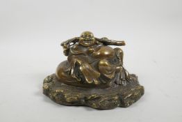 A Chinese bronze figure of a jolly Buddha reclining on a sack, impressed mark verso and to base,