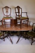 A mahogany twin pedestal dining table with solid top, reeded edge and extra leaf, raised on turned
