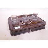 A Georgian mahogany desk stand with dished top and cut corners, fitted with glass inkwells and