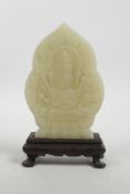 A Chinese celadon jade carving of a many faced deity on a hardwood stand, 7½" high