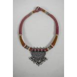 A North Indian 925 silver pendant with raised floral decoration, on a cotton choker, 17" long