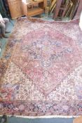 A hand woven deep pile Persian carpet, with central medallion and stylised floral designs in a muted