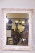 A C19th French picture frame with raised trailing vine decoration, fitted with a mirror, rebate