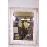 A C19th French picture frame with raised trailing vine decoration, fitted with a mirror, rebate