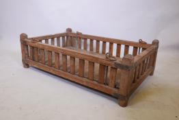 A late C19th/early C20th Indian teak hanging cot with slatted sides and brass mounts, 43" x 27",