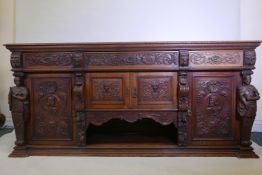 A large carved oak sideboard with three drawers divided by lion masks over cupboards, all