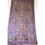 An antique Persian silk and wool carpet with vase decoration on a blue field, A/F, 78" x 43"
