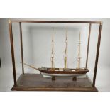 A scratch built model of a three masted ship, fitted in a glass case, 30" x 13"