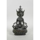 A Sino-Tibetan bronze of a many faced deity seated on a lotus throne, 9" high