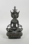 A Sino-Tibetan bronze of a many faced deity seated on a lotus throne, 9" high