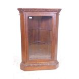 An C18th oak corner cabinet with a glazed door and carved details, 18½" x 18½", 39" high