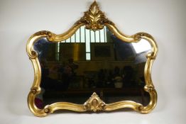 An elaborate Rococo style mirror with a gilded scrolling frame, in good condition, 32" wide x 70"