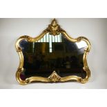 An elaborate Rococo style mirror with a gilded scrolling frame, in good condition, 32" wide x 70"