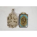 A Chinese white metal pendant decorated with a warrior, together with an Indian pendant decorated