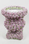 A Continental porcelain urn with all over encrusted pink glazed rose decoration, 10" high