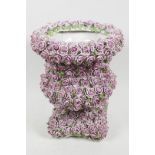 A Continental porcelain urn with all over encrusted pink glazed rose decoration, 10" high