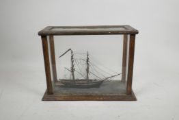 A scratch built diorama/model of a two masted ship, in a glass and wood case, 11½" x 5"