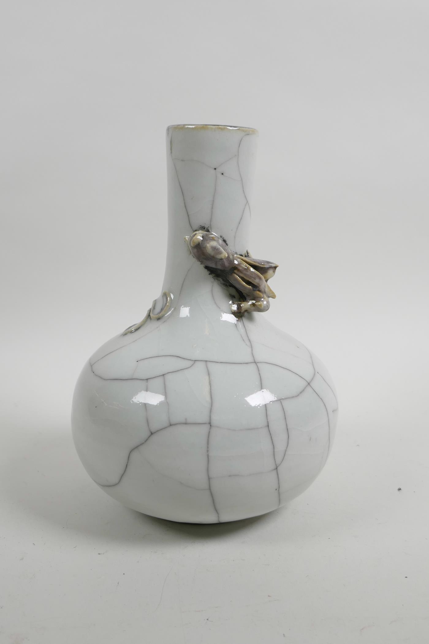 A Chinese crackle glazed pottery bottle vase decorated with a climbing dragon to the neck, 7½" high