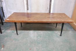 A mid century Meredew teak coffee table, raised on ebonised supports, 18" x 46" x 14"